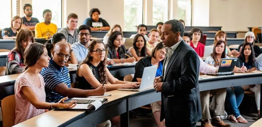 Teacher with students in lecture hall.